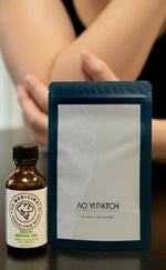 Bottle and packaging of Ao Yi Patch on a reflective surface with a blurred background