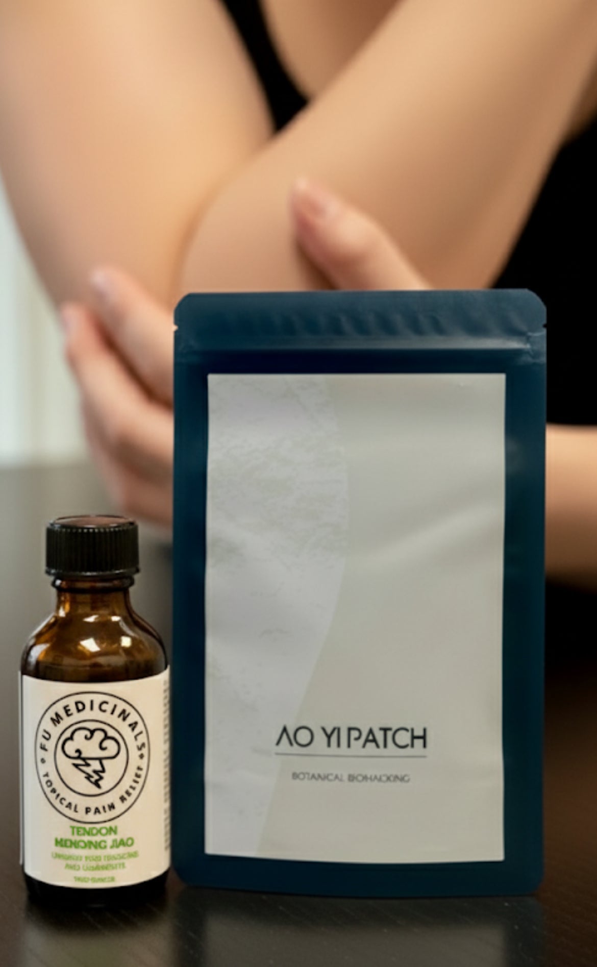 Bottle and packaging of Ao Yi Patch on a reflective surface with a blurred background